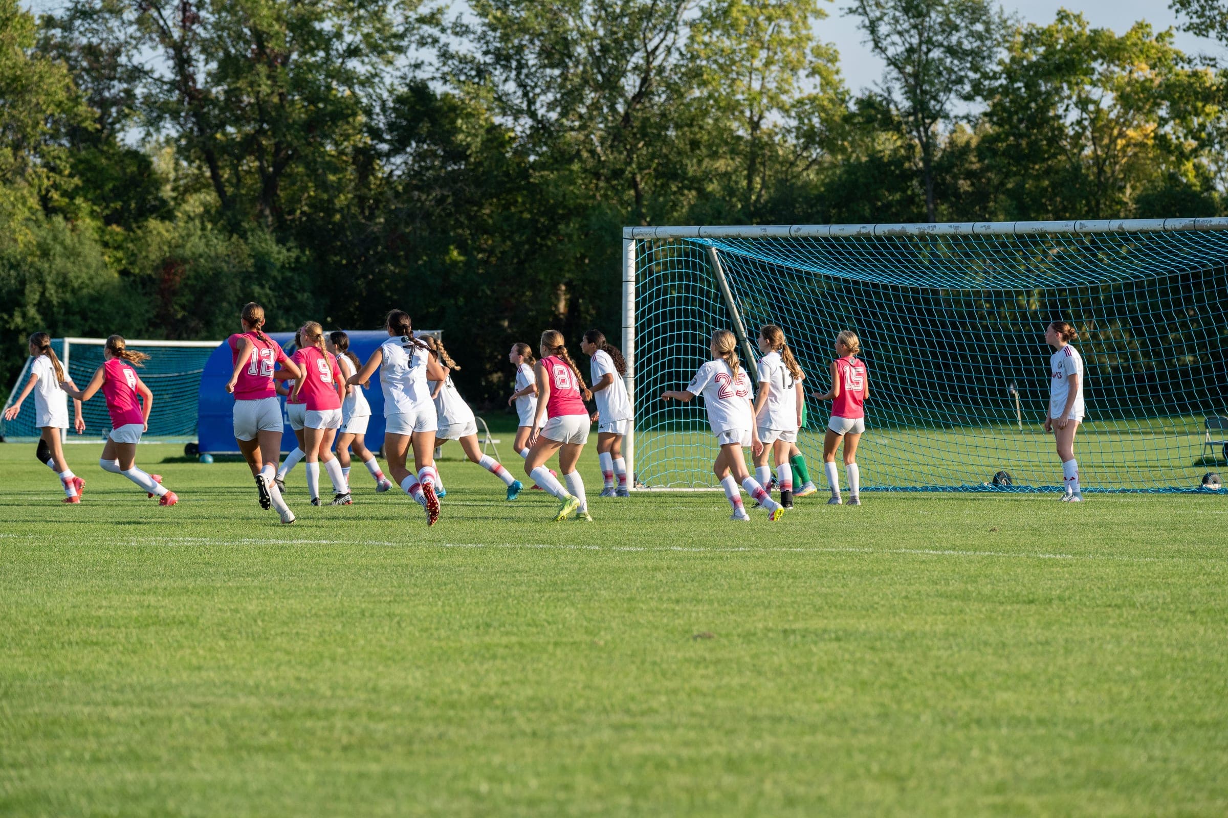 Youth soccer players moving toward goal in Chicagoland match coverage